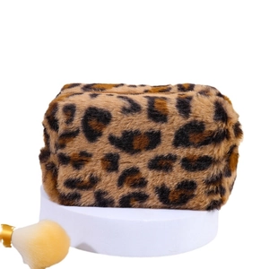Large capacity leopard print plush makeup bag with zipper closure on a white podium