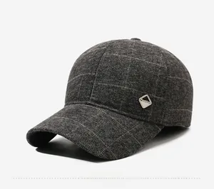 Dettaglio cappello da baseball in lana a quadri grigio scuro con stemma in metallo laterale