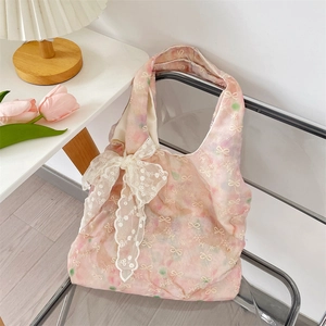 Close-up of pink floral tote bag featuring a delicate white lace bow with sequins