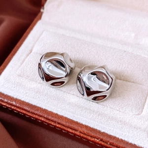 Macro detail of silver liquid metal stud earrings with irregular geometric texture