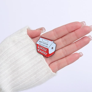 Cooler box enamel brooch pin with Don't Hate Me lettering on white knit sweater