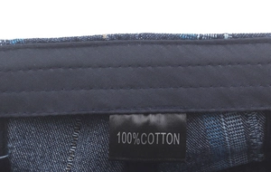 Close-up of 100% cotton label on a blue denim beret with reinforced stitching details