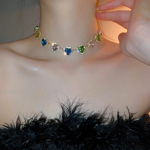 Dettaglio della collana a cuore con pietre colorate, placcatura oro e bordo in zirconi