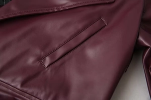 Detailaufnahme der Seitentaschen-Naht an einer weinroten Lederjacke für Damen