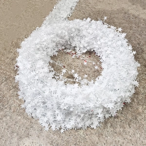 Close-up of white star-shaped Christmas tinsel garland rolls for festive DIY decoration