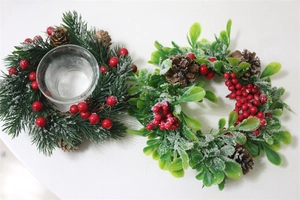 Detail of Christmas candle holder wreaths with faux pine needles, pinecones and red berries