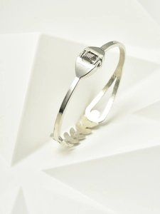 Detail of silver wheat leaf bangle with spring hinge closure on a white stand