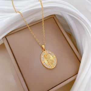 Dettaglio della collana con medaglione ovale dorato con icona a rilievo e cristalli