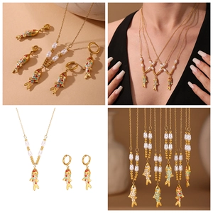Detail view of gold koi fish jewelry set with colorful enamel and pearl accents