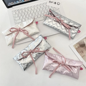 Trousse à nœuds matelassés en satin, lot de quatre couleurs sur un bureau moderne