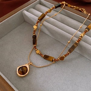 Detail of gold-plated double-layer necklace with brown tiger eye stone in jewelry box