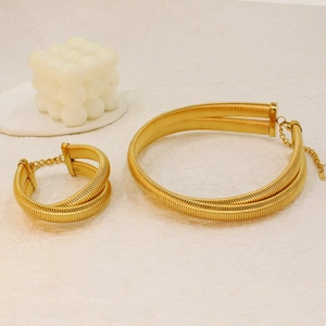 Detailed view of golden double-layer woven necklace and bracelet set on beige background
