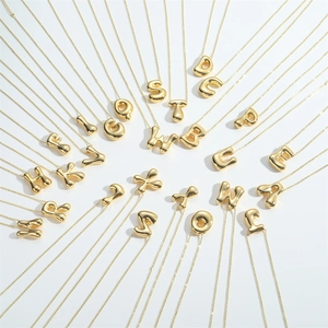 Golden 3D bubble letter pendant necklaces arranged in a circular radiating pattern on white