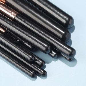Detail of black pearlized handles and rose gold ferrules of the makeup brush set