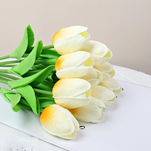 Detailed close-up of cream-white artificial tulips with realistic green stems and leaves