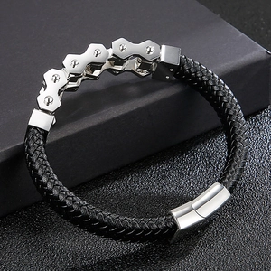 Close-up of black braided leather men's bracelet with gear-shaped steel ornaments