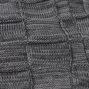 Detail shot of the gray basketweave knit pattern on a thick winter beanie with soft texture