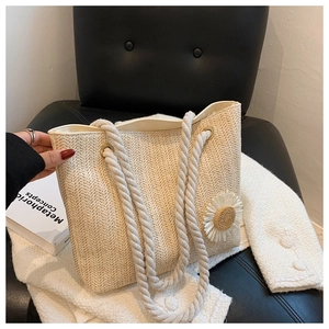 Detail of beige straw woven tote with white daisy flower and thick cotton rope handles