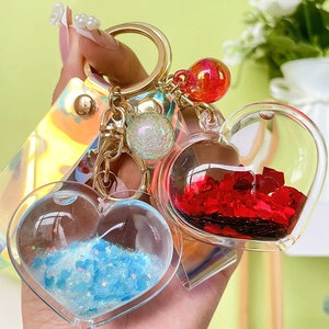 Handheld liquid glitter heart keychain with iridescent strap and gold metal ring