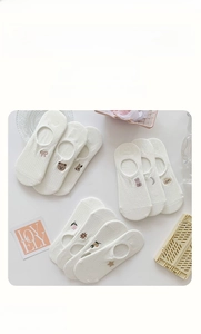 Detail of white cotton no-show socks with cute animal embroidery and elastic cuffs