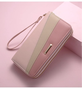 Detail view of pink and beige triple-color patchwork wallet with dual zippers and wrist strap