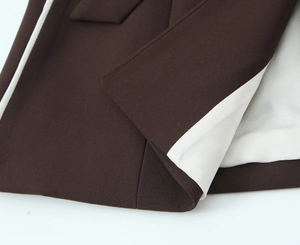 Detailed view of dark brown twill fabric with white lining and neat stitching quality