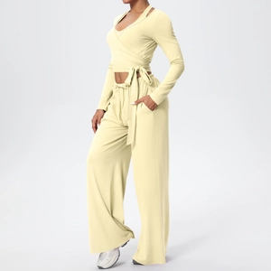 Détail d'ensemble de yoga jaune avec haut croisé à manches longues et pantalon large