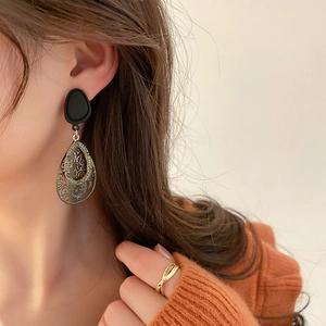 Close-up of model wearing vintage black drop earrings with rhinestone hollow patterns