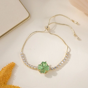 Détail du bracelet doré ajustable avec trèfle à quatre feuilles vert et zircon brillant