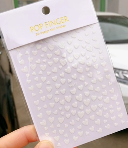 Close-up of Me017 3D glittery white heart nail art stickers in official packaging