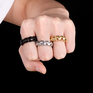 Mens gold silver and black stainless steel chain rings shown on a hand with black background
