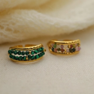 French style gold titanium steel rings with malachite beads on soft beige fabric