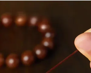 Detail of high-elastic crystal cord used for natural golden silk phoebe wood beads