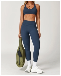 Vue complète d'une femme en ensemble de yoga bleu poudré avec legging et brassière sport