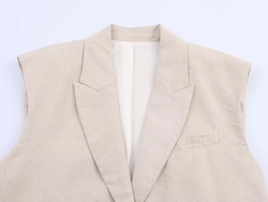 Gros plan du gilet en lin avec revers cranté montrant la texture du tissu beige avoine