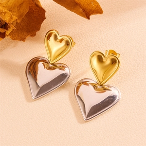 Detail of two-tone stainless steel heart earrings with polished gold and silver finish