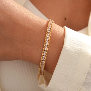 Detail of gold chain bracelet with round-cut crystals and twisted rope metal borders