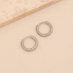 Detailed view of silver titanium steel hoop earrings with polished finish and hinged clasp