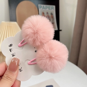 Detailed view of soft pink rabbit fur hair clips with secure metal bb clips for kids