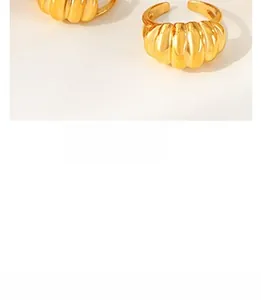 Gros plan d'une bague croissant plaquée or avec une texture métallique côtelée polie