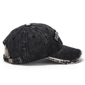 Detail view of washed black cotton baseball cap with distressed holes and leopard peak