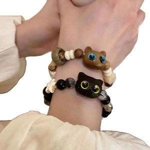 Beaded bracelets featuring cute cat pendants in brown wood and black ceramic styles