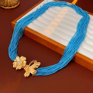 Detail of multi-strand blue beaded necklace with gold butterfly and flower clasp