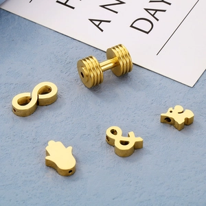 Golden DIY jewelry pendants including elephant and infinity shapes on blue background