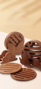 Detailed view of animal-shaped ebony wood coasters with natural grain and heat resistance