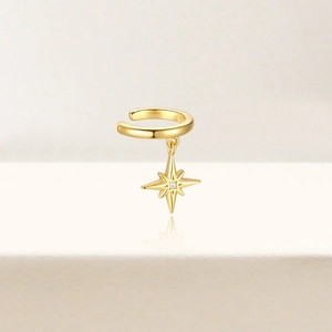 Detail of a gold star drop ear cuff with a tiny diamond in a minimalist stylish design