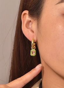 Primo piano di modella che indossa orecchini ottagonali in smalto verde e zircone rosa