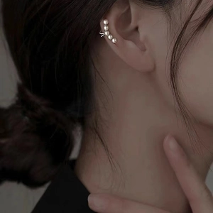 Elegant 925 silver plated ear cuff with five pearls on a female model's ear