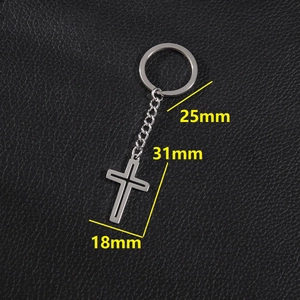 Polished stainless steel cross pendant keychain on black leather background, 31mm size