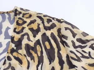 Detail shot of leopard print chiffon fabric featuring neat stitching and sheer texture